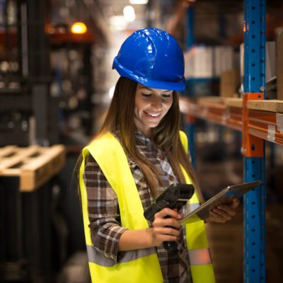 smiling-female-worker-holding-tablet-bar-code-scanner-checking-inventory-distribution-warehouse